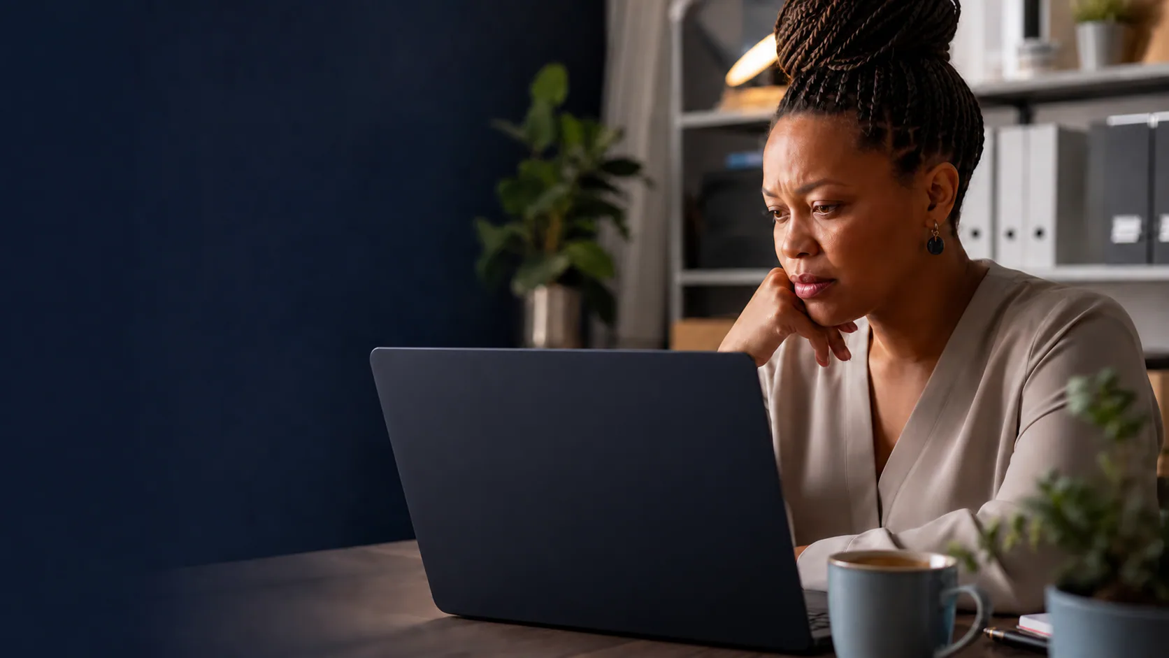 Business owner reviewing overdue invoice reminders on a back-facing laptop